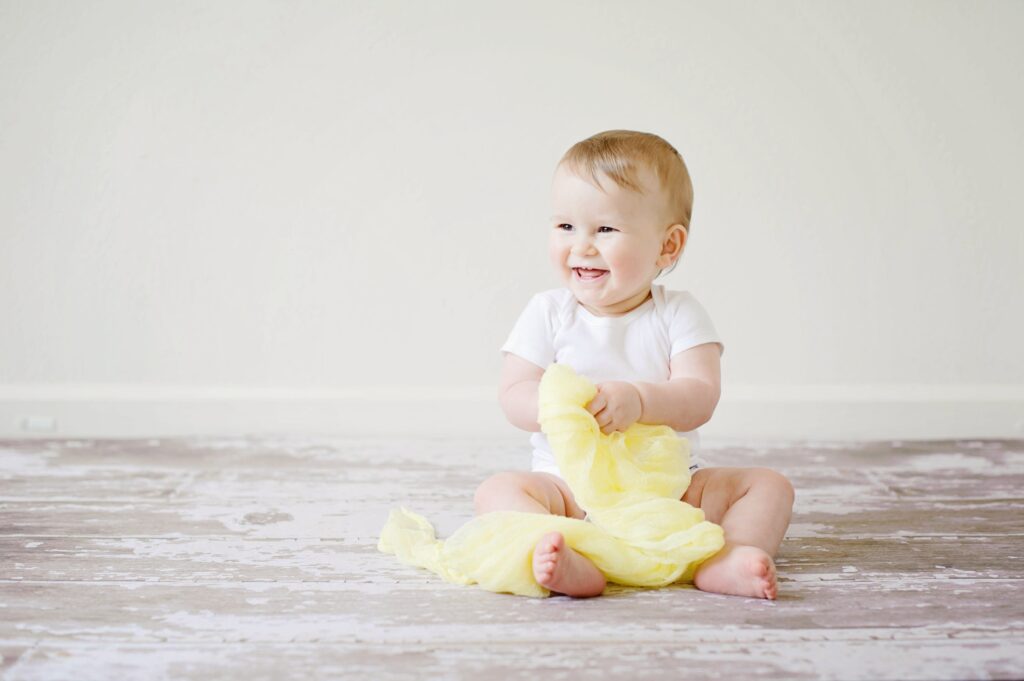 Baby smiling with yellow blanket