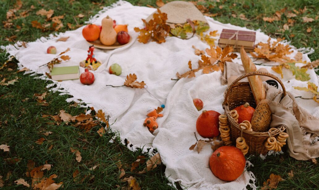 Fall Foods on a blanket outside with pumpkins, leaves